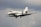 View of a modern private jet soaring above clouds during golden hour.