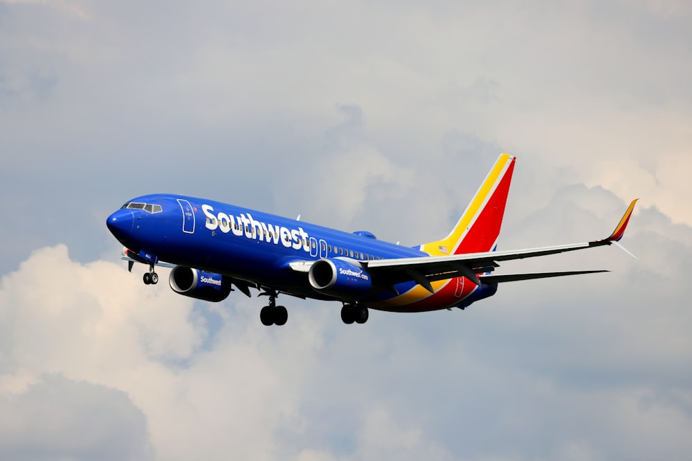 a blue and white airplane flying in the sky