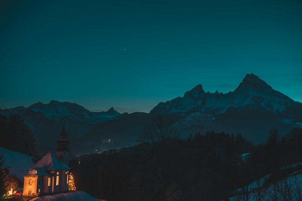 a building with a tower in front of a mountain