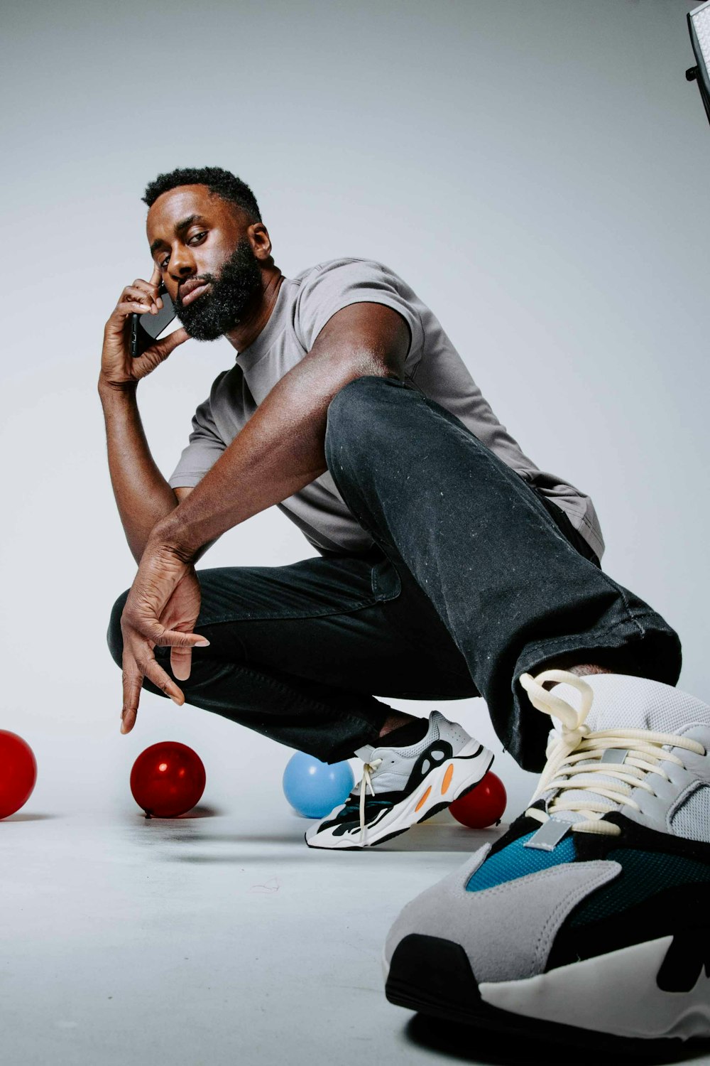 a man sitting on the floor talking on a cell phone