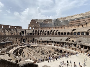 a large ancient building with many people with Colosseum in the background