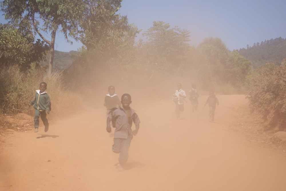 a group of people walking in a dirt field