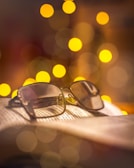 Close-up of a pair of ZoomToGo reading glasses resting on an open book with soft natural light.