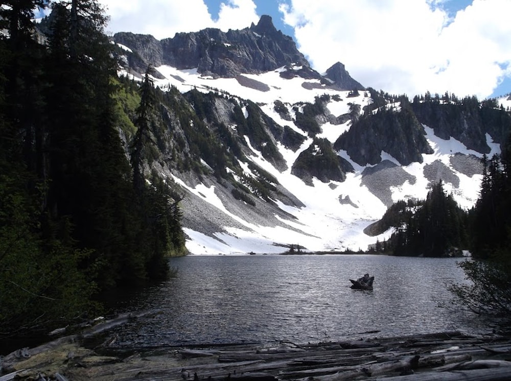 a boat in a lake with snowy mountains in the background