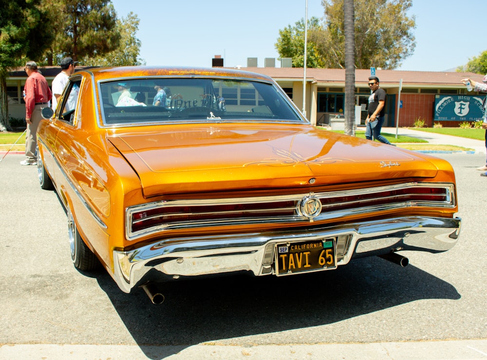 an orange car parked on the side of the road