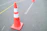 Close-up of bright orange traffic cones lined up along a busy Mumbai street.
