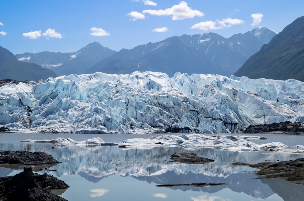 a body of water with ice and snow on it with Matanuska Glacier in the background