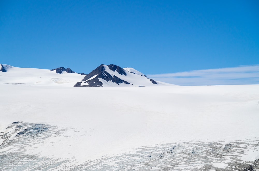 uma paisagem nevada com uma montanha à distância