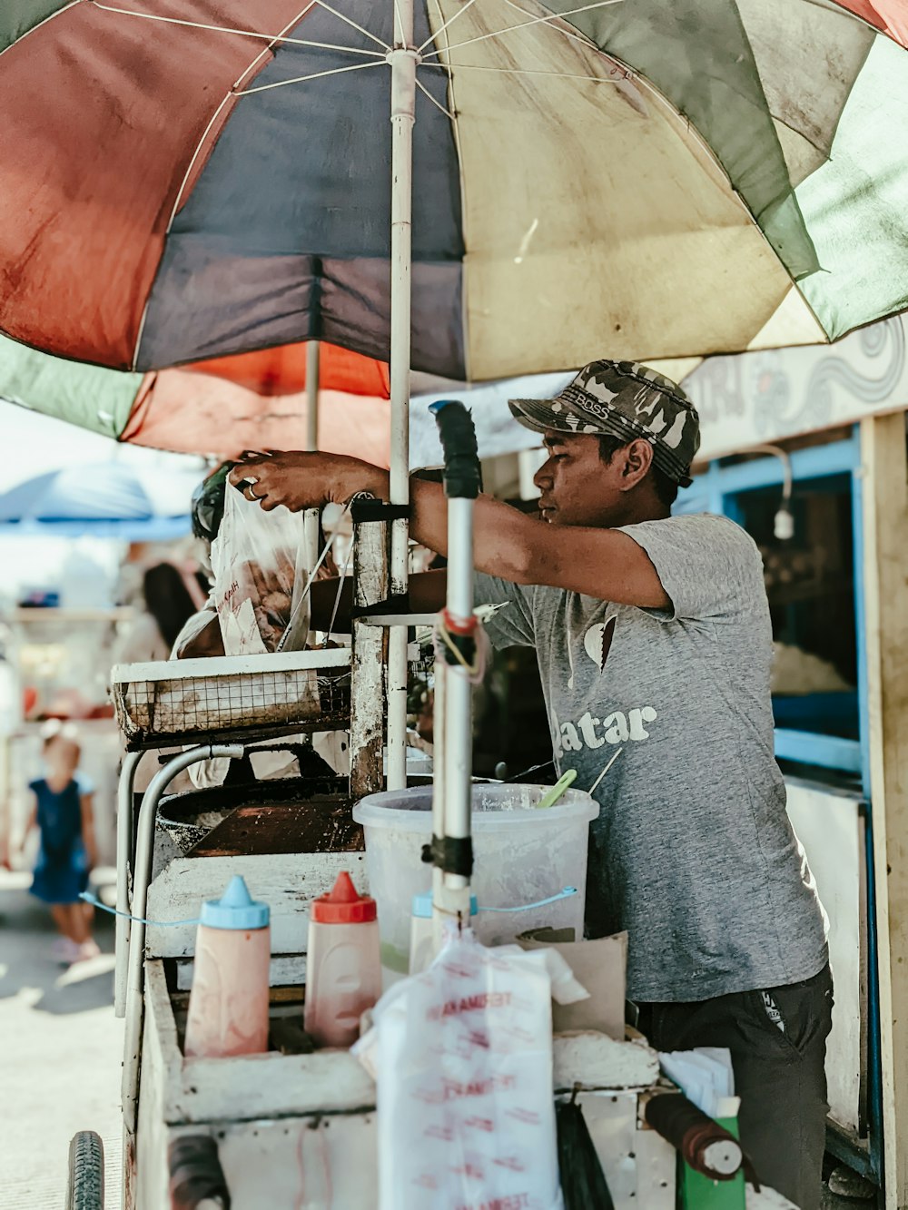 eine Person, die Lebensmittel unter einem Regenschirm verkauft