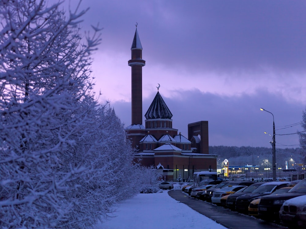 a building with a tower and cars parked in front of it