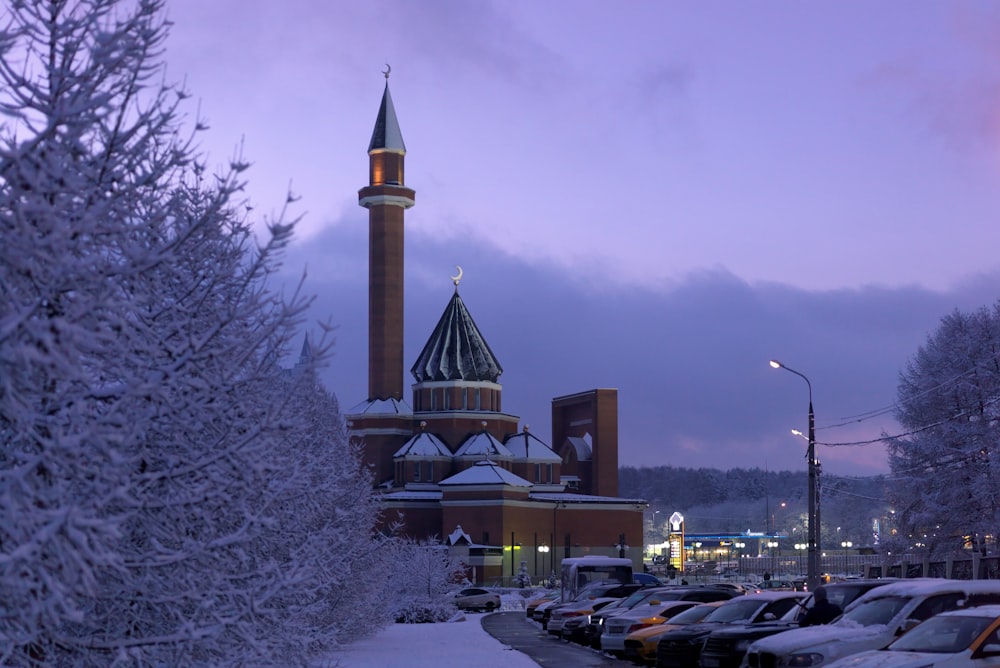 a building with a tower and cars parked in front of it