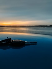 A close-up of a rental car key with a sunset in the background.