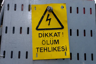 a yellow sign on a white wall