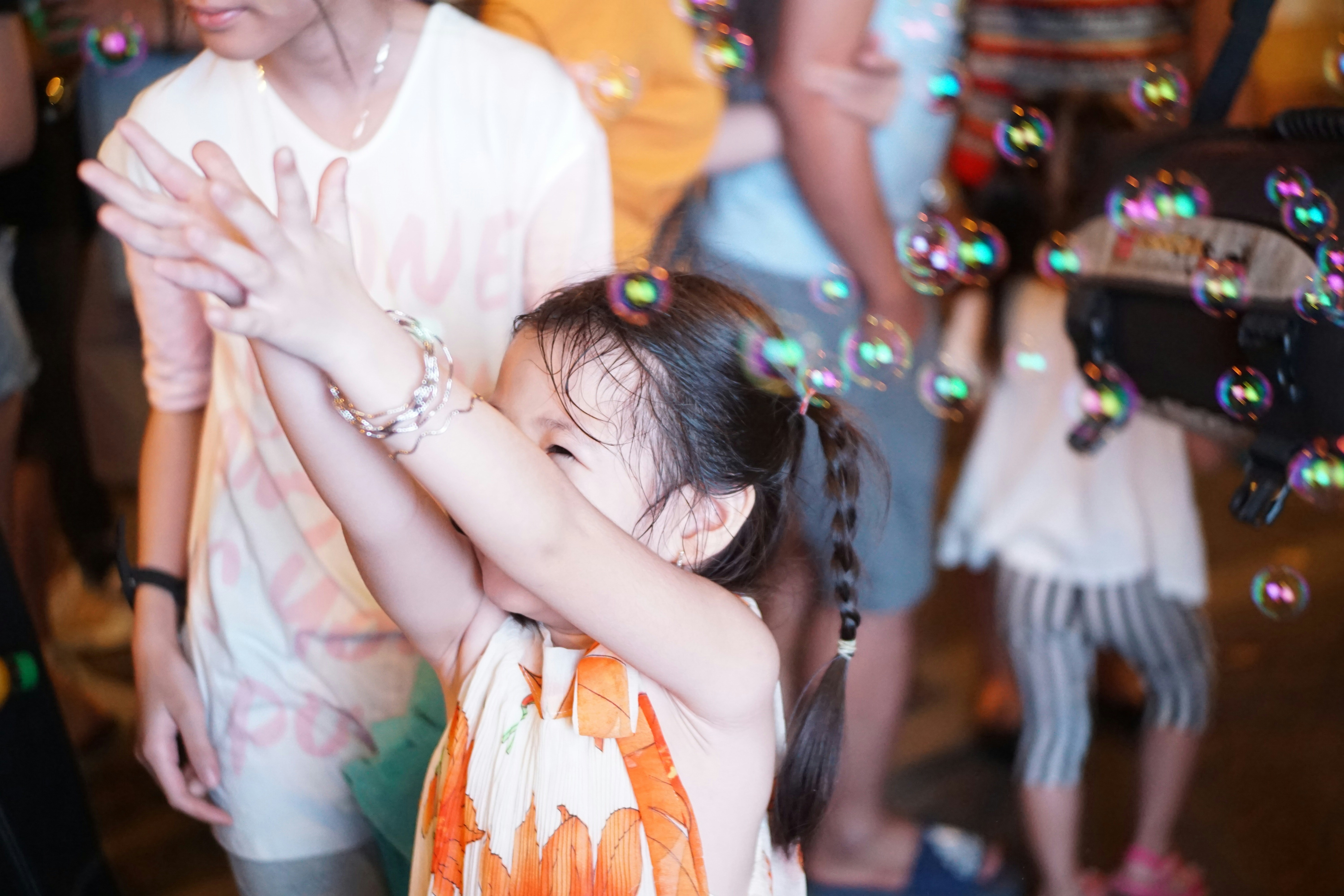 A little girl standing in front of a group of people