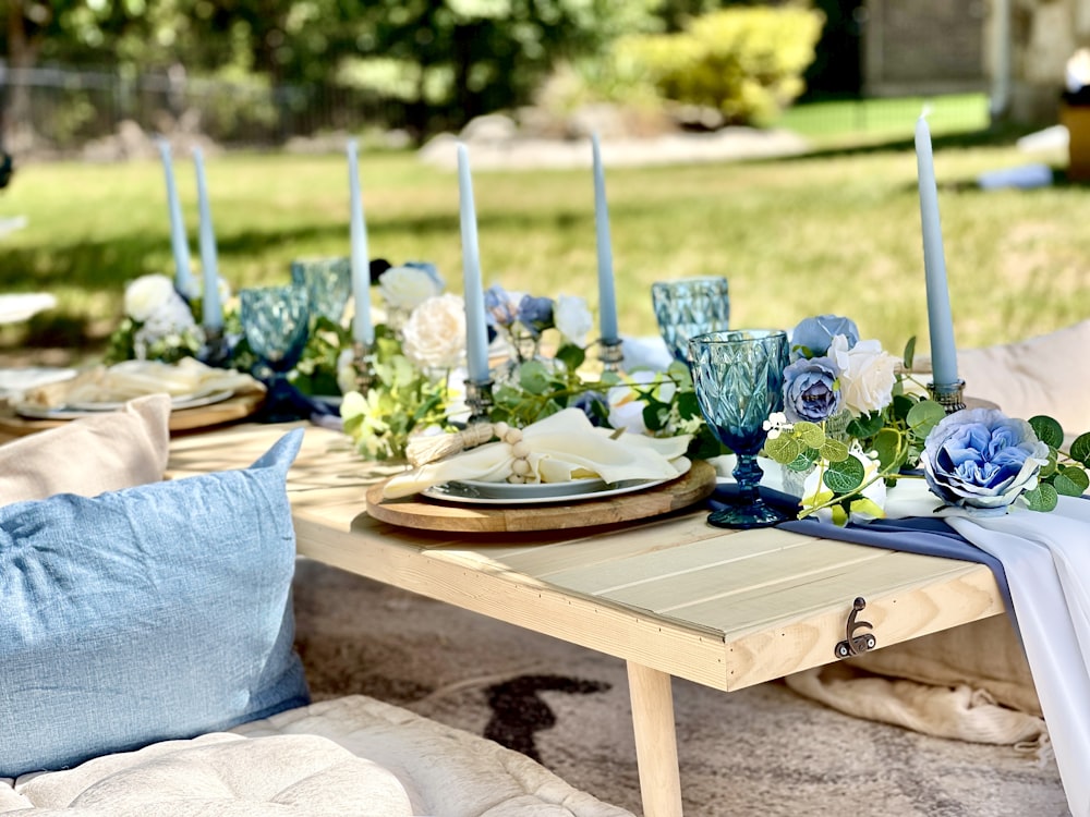 a table with a tray of flowers and candles on it