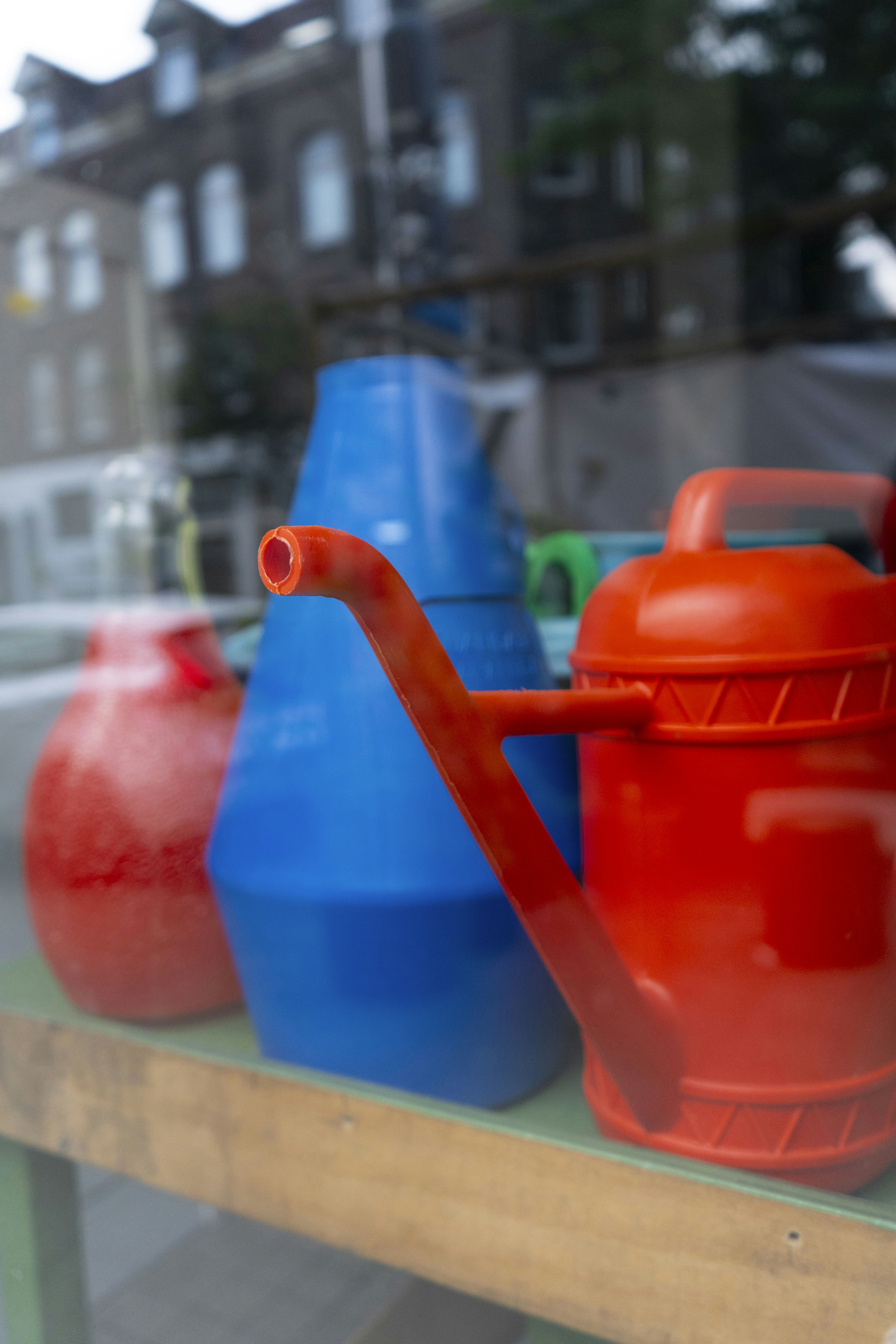 a group of colorful vases sit on a window sill
