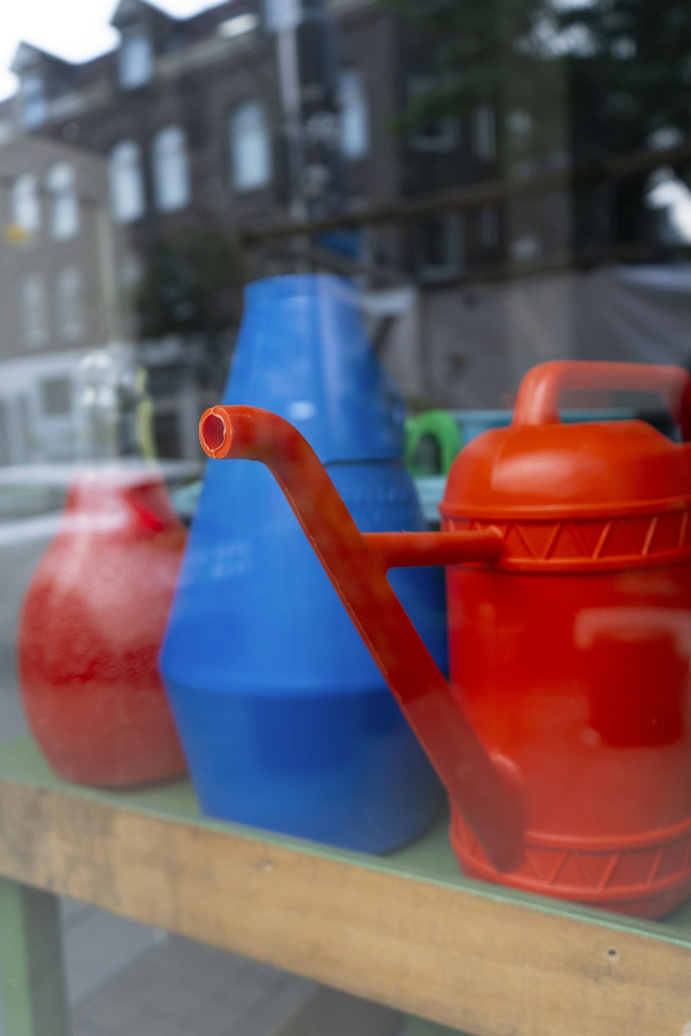 a group of colorful vases sit on a window sill