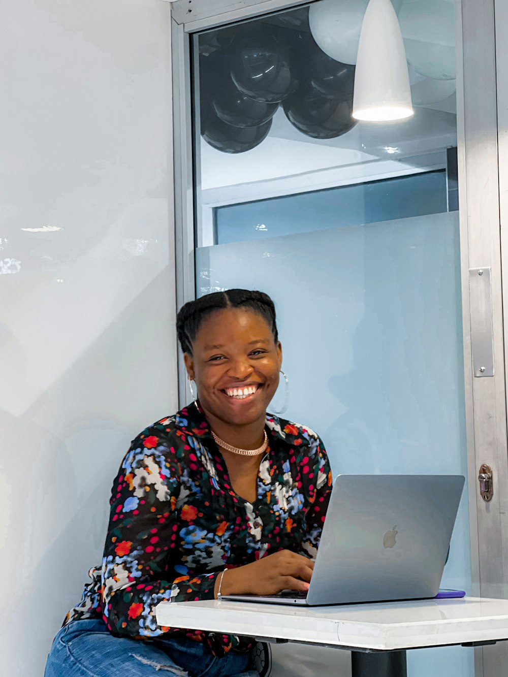 a person smiling while holding a laptop