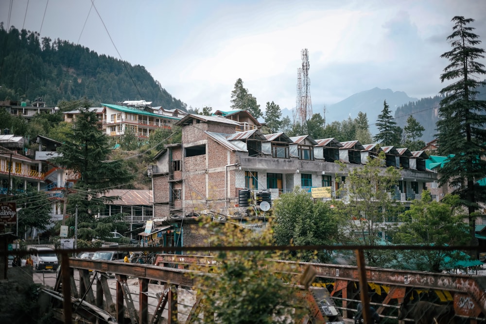 a group of buildings with trees and mountains in the background