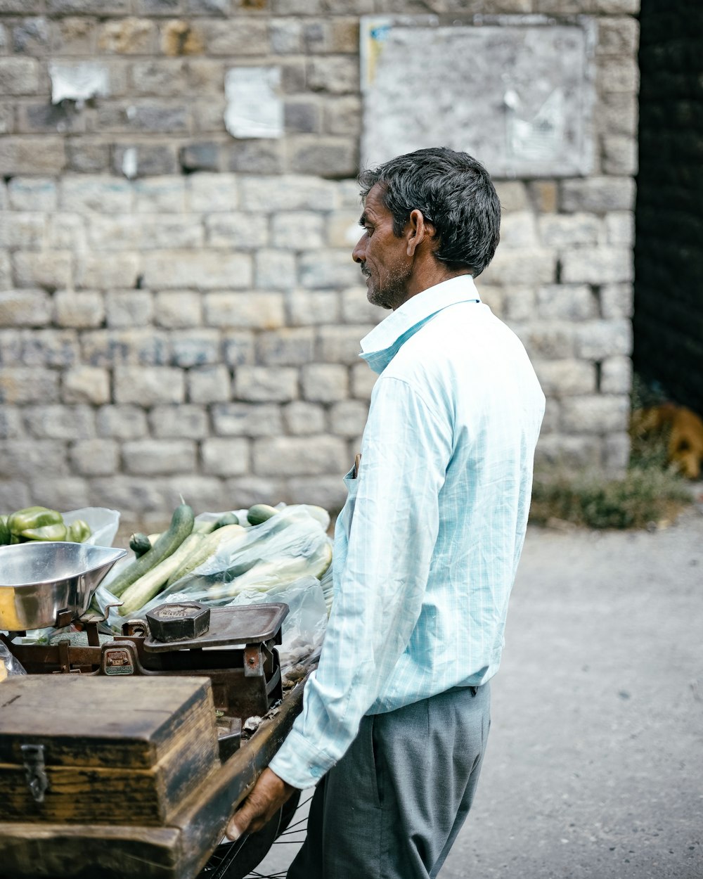 a man standing next to a grill with vegetables