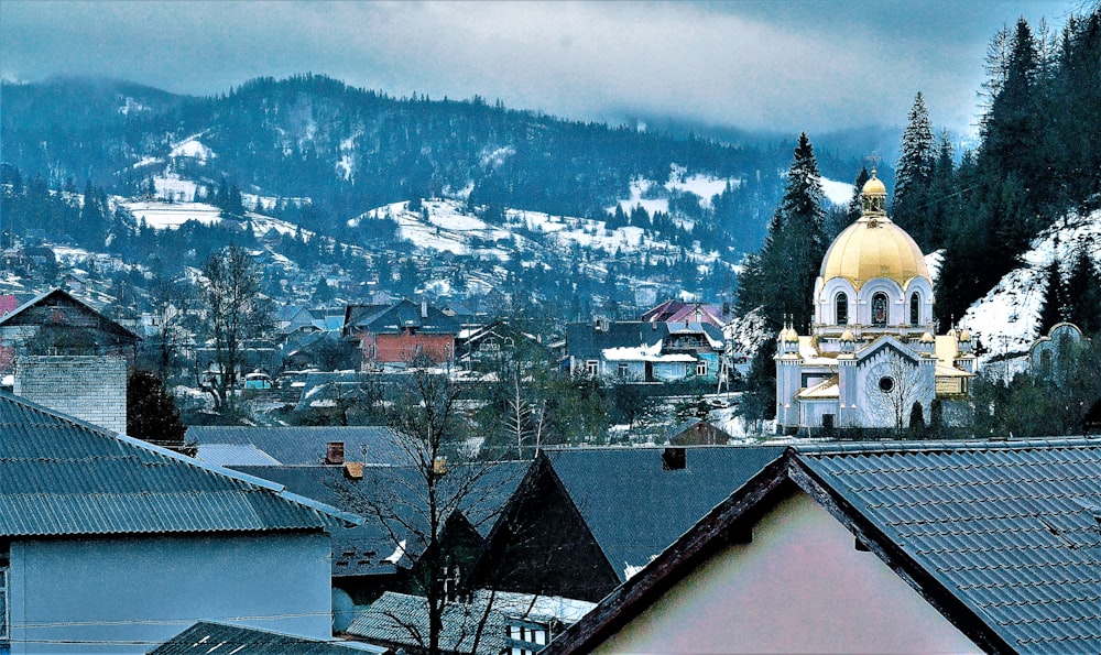 a building with a gold domed roof and a gold domed roof with a mountain in the background