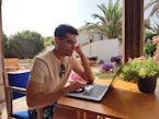 a person sitting at a table with a laptop