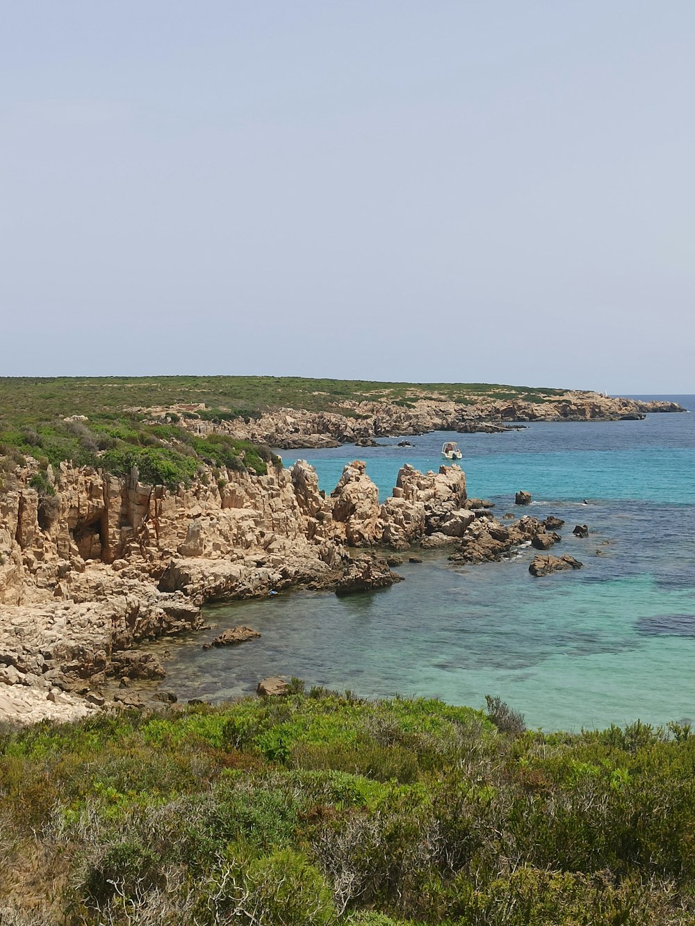 Ein felsiger Strand mit einem Gewässer im Hintergrund