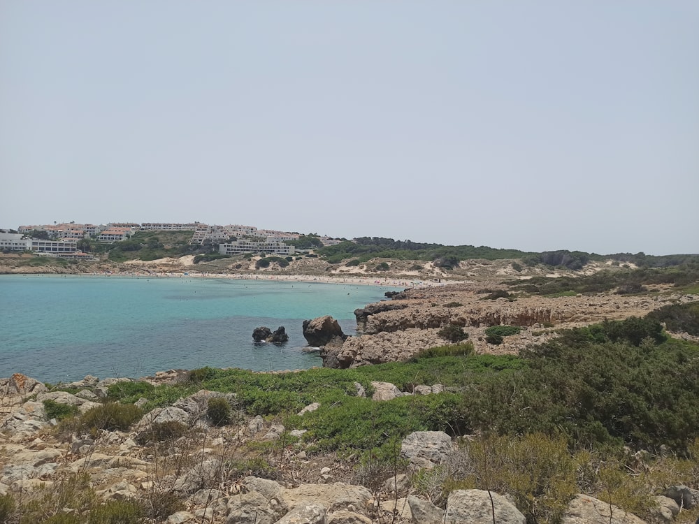 a rocky beach with a city in the background