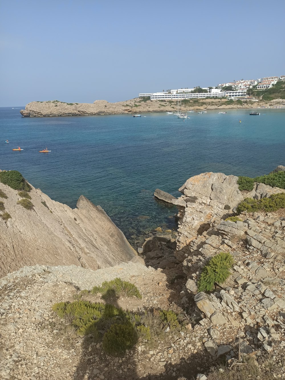 a rocky beach with a building in the background