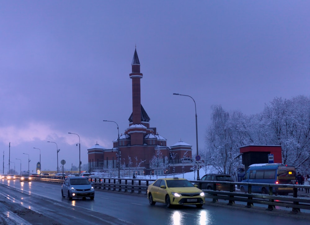 cars on a road with a tower in the background