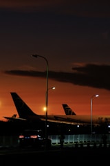 Sunset view over the runway with jets parked at hangars.