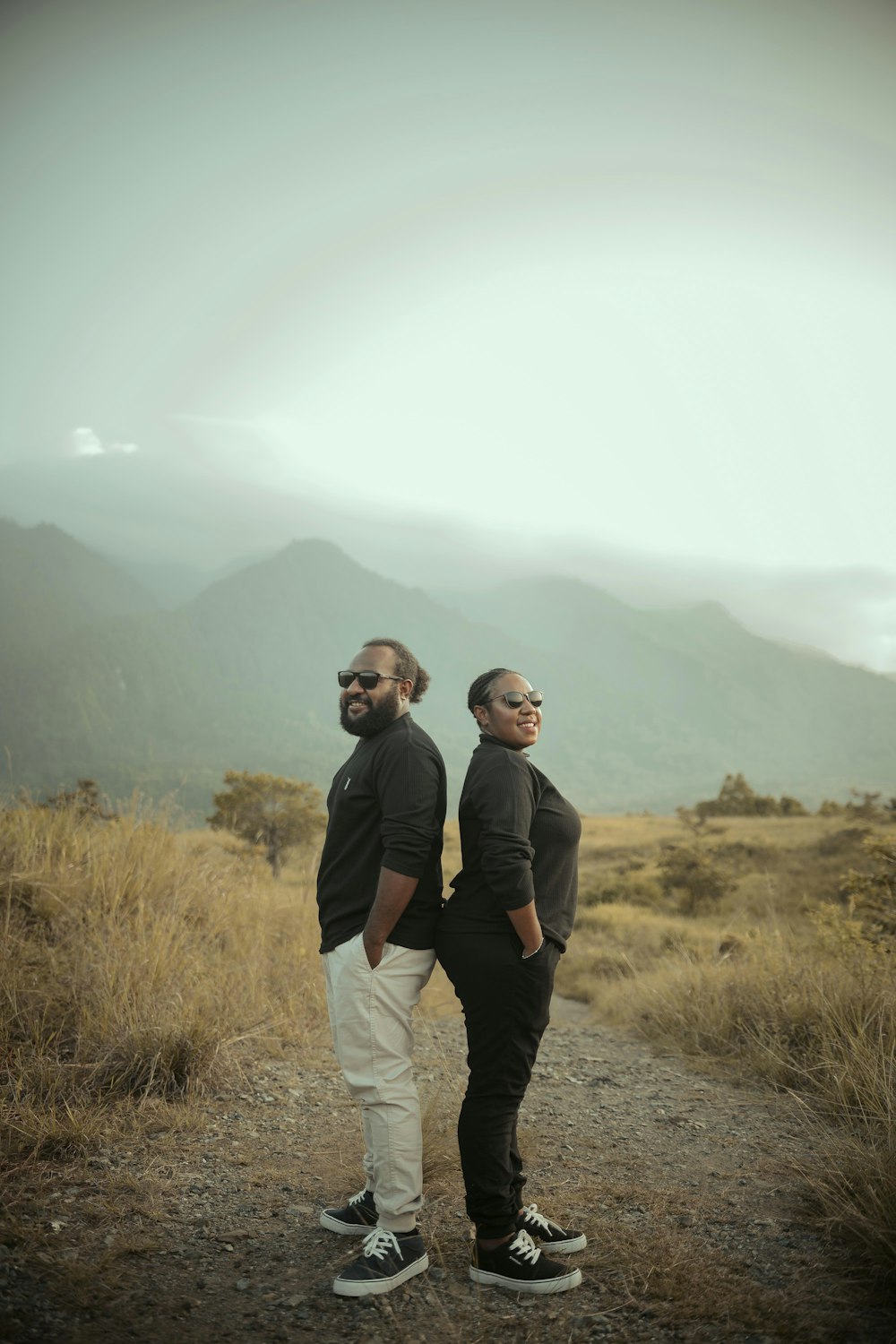 two men standing on a dirt road