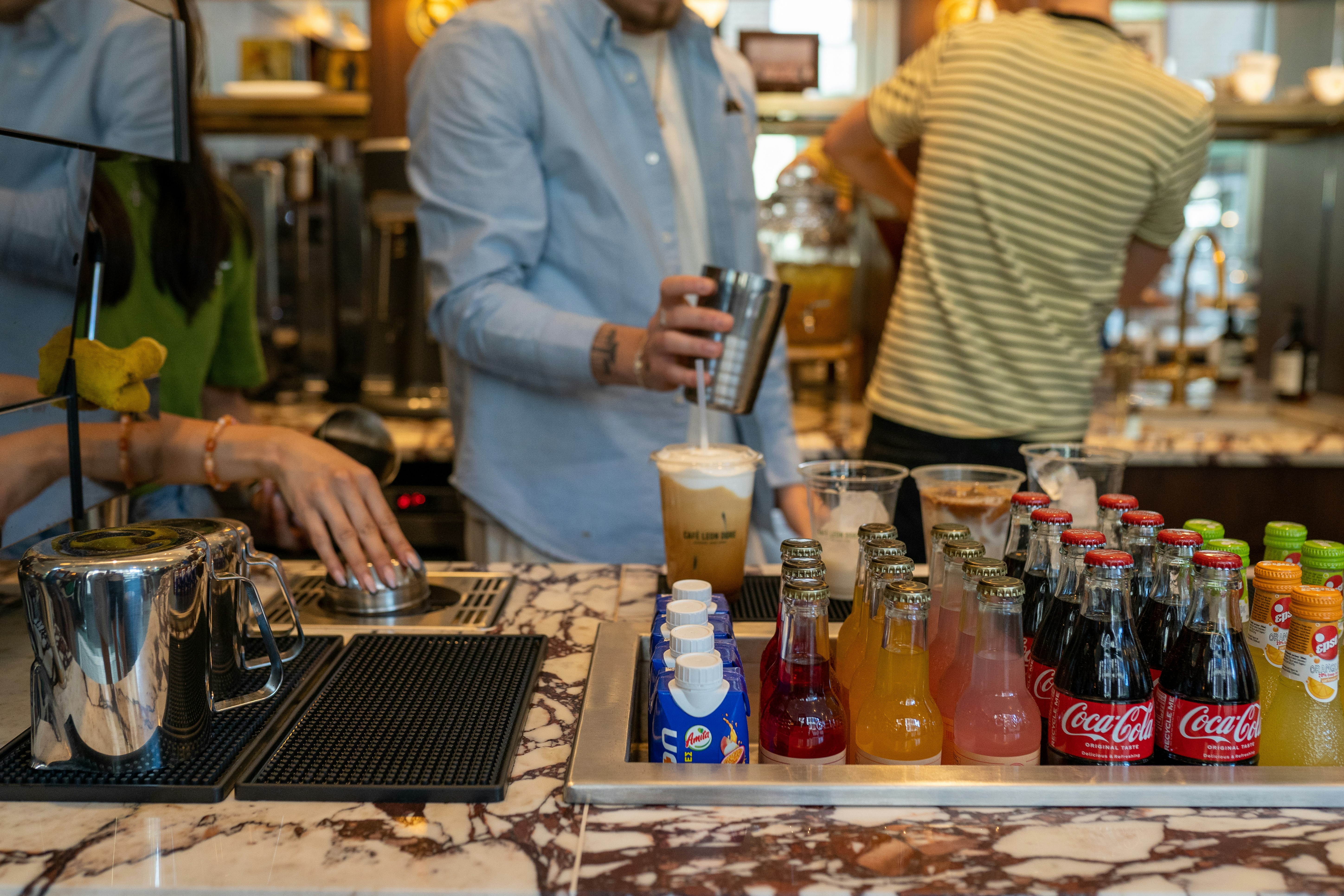 Un gruppo di persone in piedi intorno a un bar con bevande