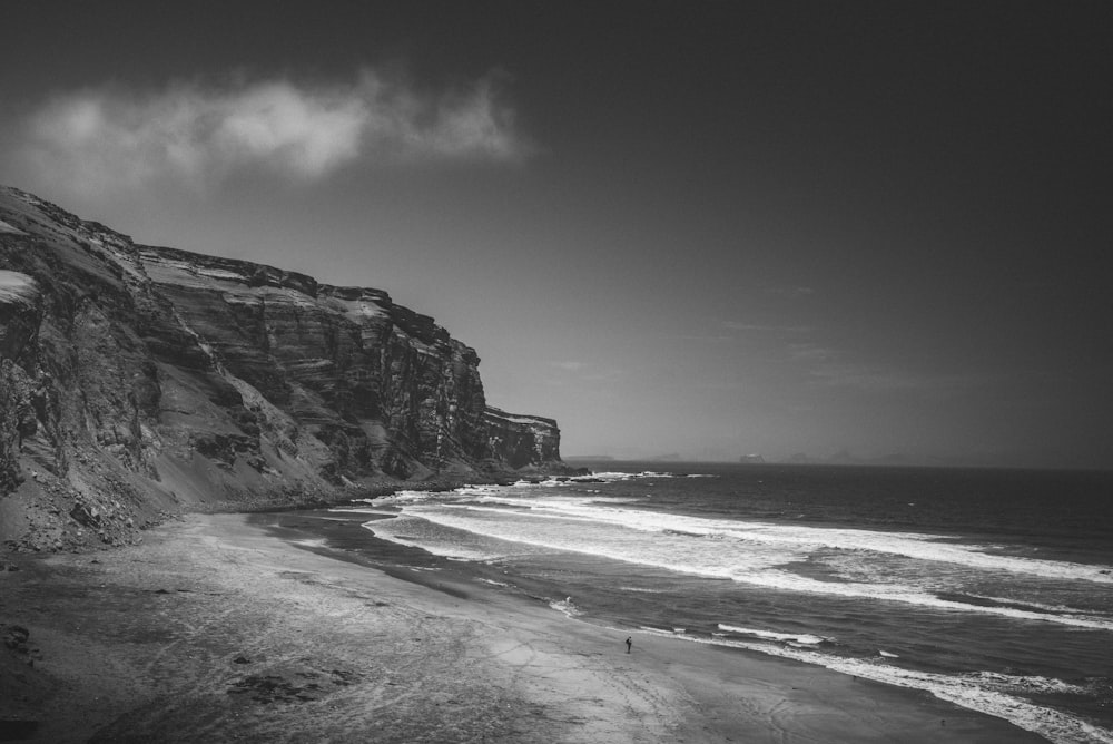 a beach with a cliff and water