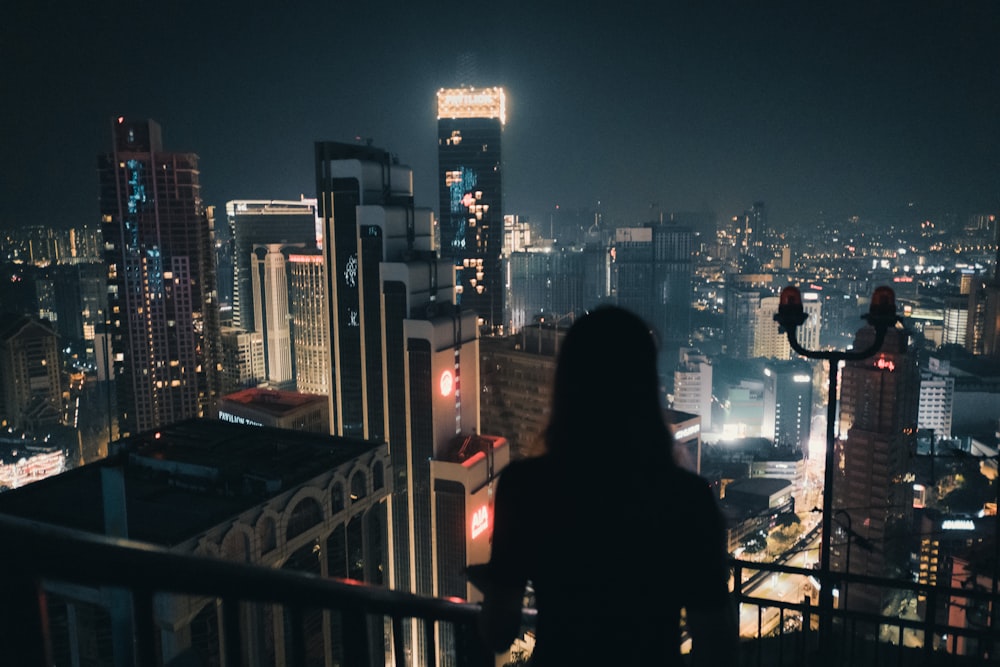 a person looking out over a city at night