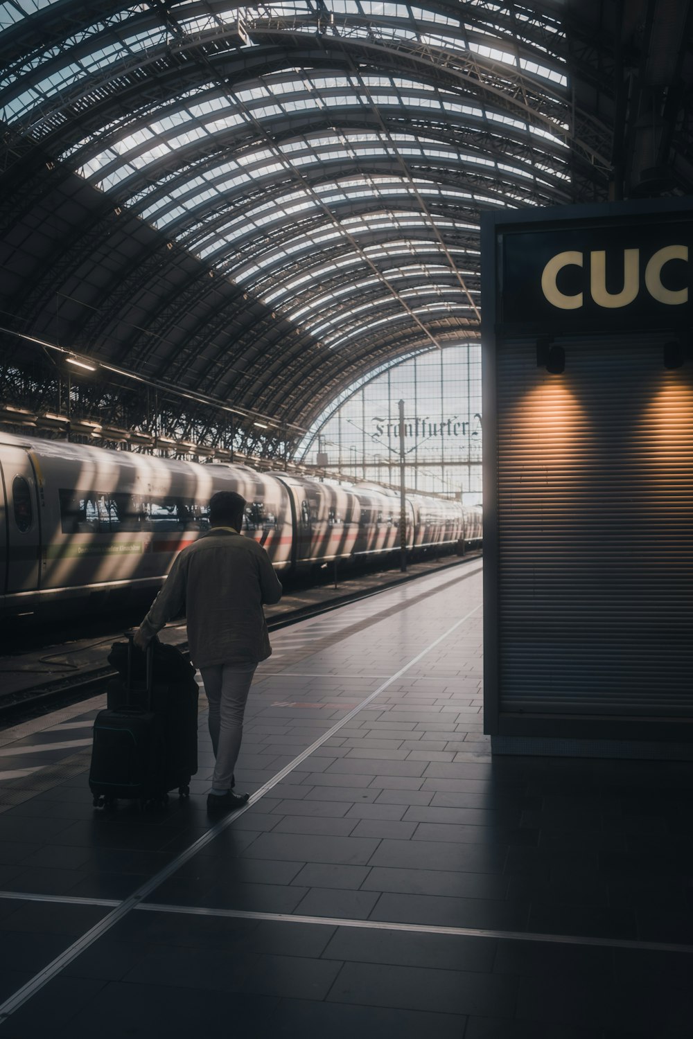 a person with a suitcase walking in a train station