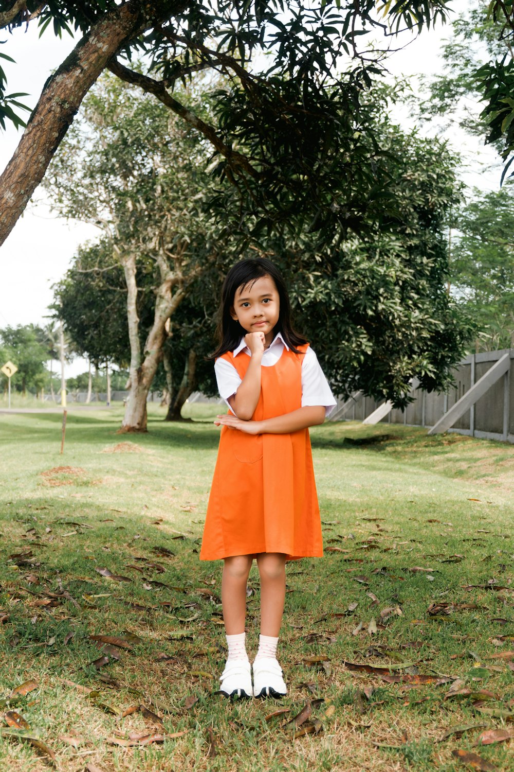 a girl standing under a tree