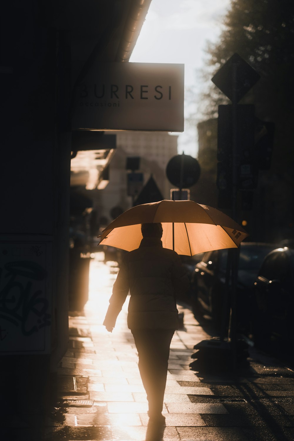 a person walking down a sidewalk with an umbrella