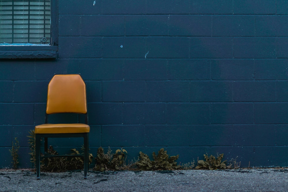 a chair sits in front of a blue wall