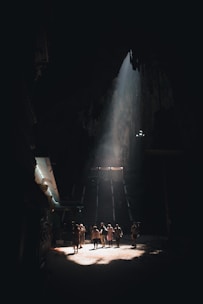 A group of tourists exploring ancient Taino caves with sunlight streaming in.