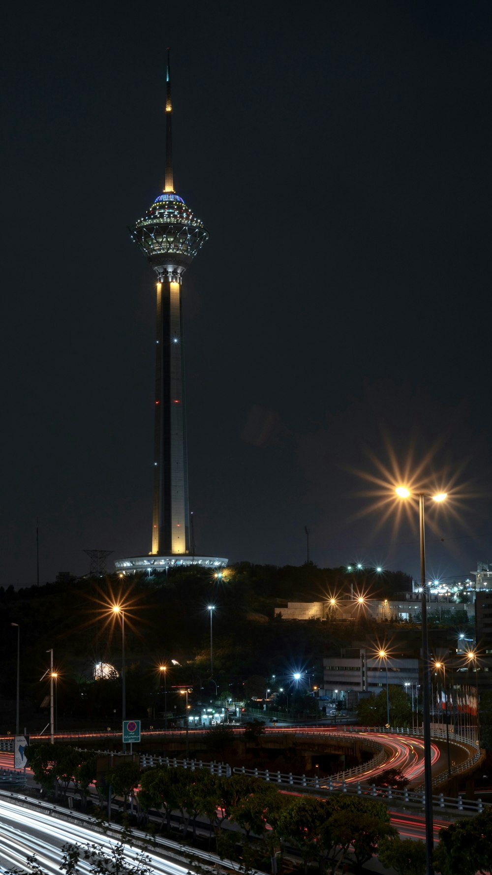 a tall pointy tower with lights at night