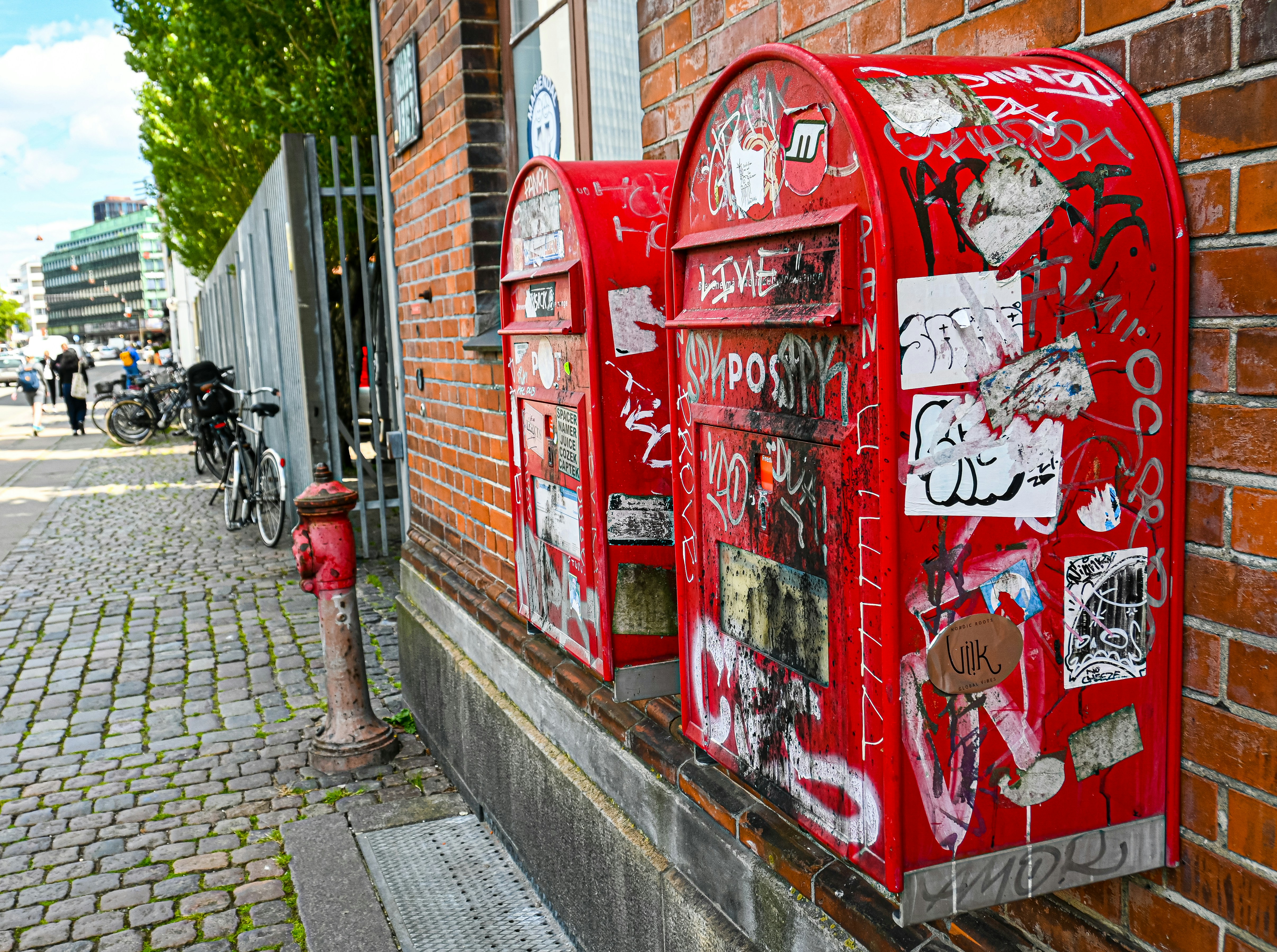 a red fire hydrant next to a wall covered in graffiti