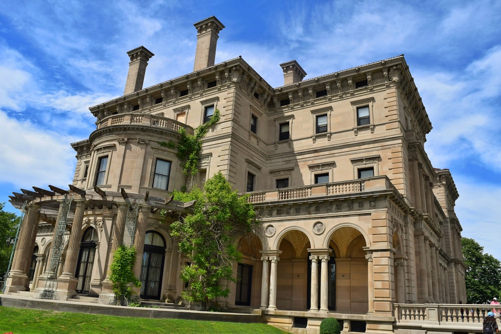 un grand bâtiment avec des colonnes et une pelouse devant lui avec The Breakers en arrière-plan