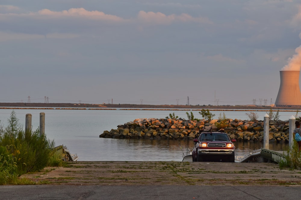 a car parked on a road by a body of water