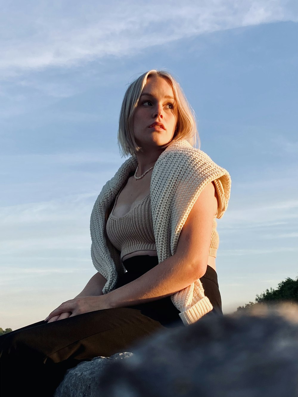 a woman sitting on a rock