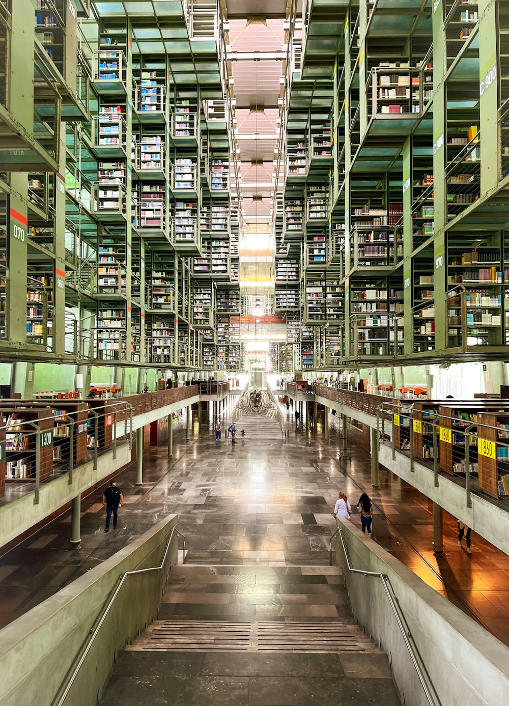 a long hallway with people and bookshelves