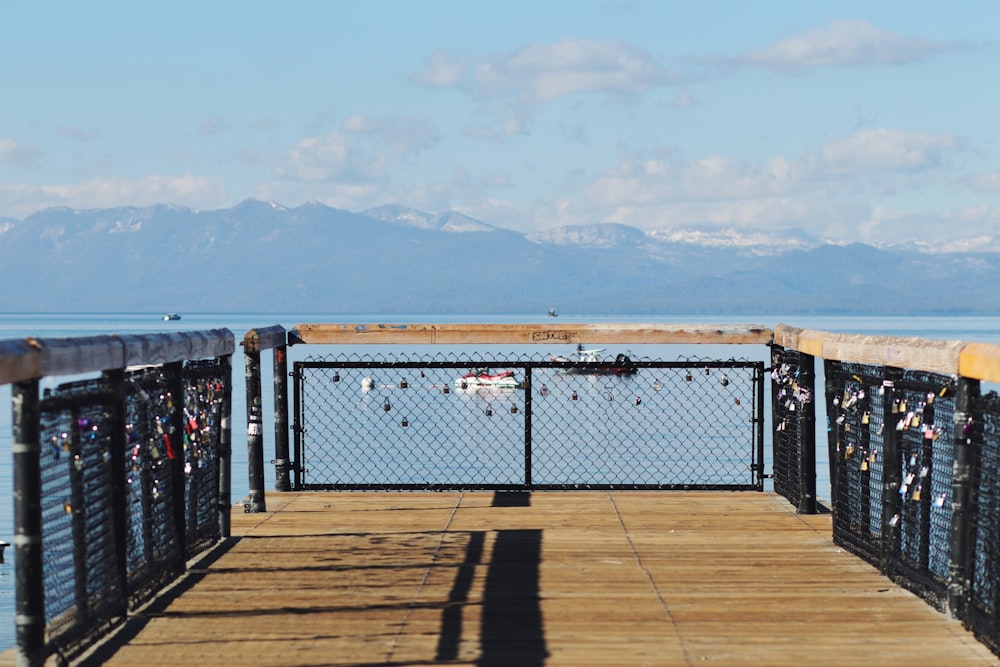 a wooden deck overlooking a body of water and mountains