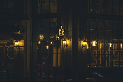 The softly glowing Shuaa Coffee sign outside the shop as dusk settles, inviting evening visitors.