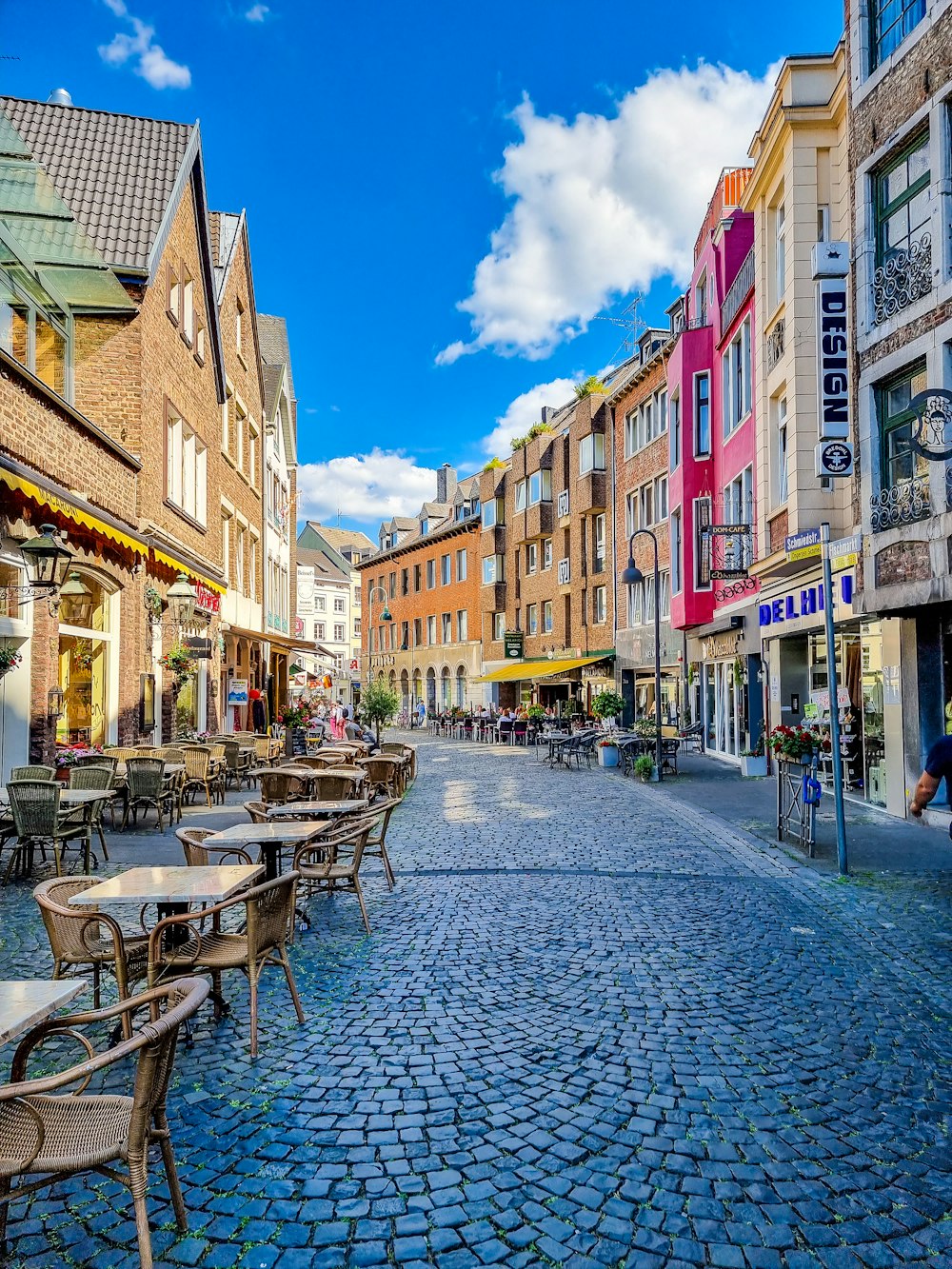 a cobblestone street with tables and chairs on it