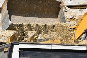 A dumpster being loaded with construction debris.